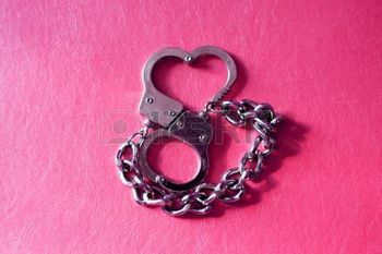 5853173-metal-handcuffs-in-shape-of-heart-at-red-background (1)
